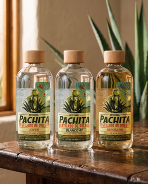 Pack de 3 botellas Pachita destilado de pulque: Joven, Blanco 47 y Reposado sobre mesa de madera